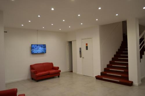 a red chair in a room with a staircase at Hotel Astro in Mar del Plata