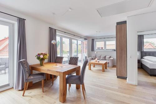 a dining room and living room with a table and chairs at Apartmenthaus Emily by POLY Hohwacht in Hohwacht