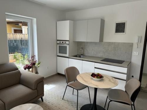 a kitchen with a table and chairs and a couch at Apartments Tenerifa in Novigrad Istria