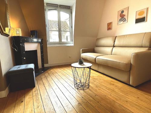 uma sala de estar com um sofá e uma mesa em Vue Royale, Cœur Ville, lumineux #5 em Dreux