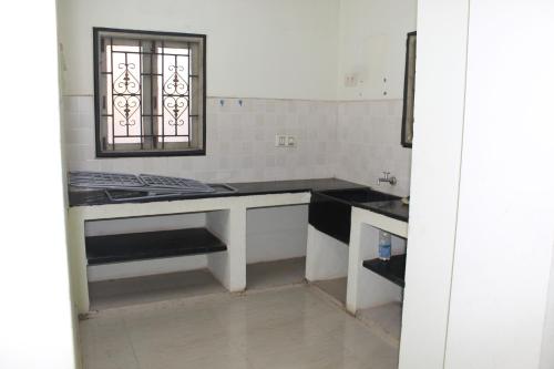 a kitchen with a table and a window in it at Centaurus Homestay near Trichy Airport in Tiruchchirāppalli