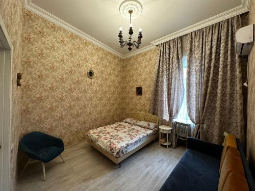 a bedroom with a bed and a couch and a chandelier at STEPROOMS in Tbilisi City