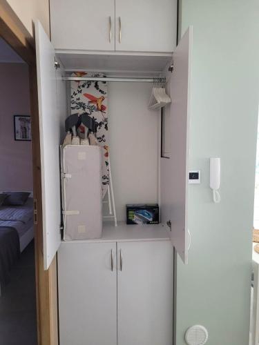 a small kitchen with white cabinets and a refrigerator at Apartament Wałowa in Wejherowo