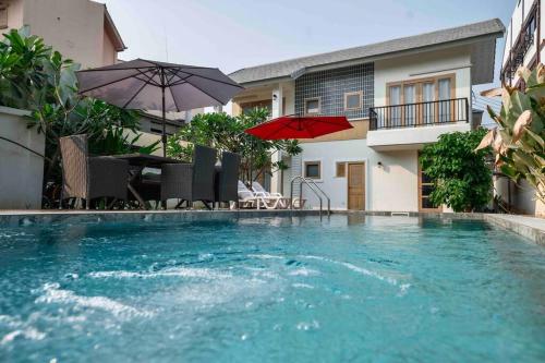 a swimming pool with chairs and umbrellas next to a house at 5BR PoolVilla On the Old City Moat ⁜Best Location⁜ in Chiang Mai