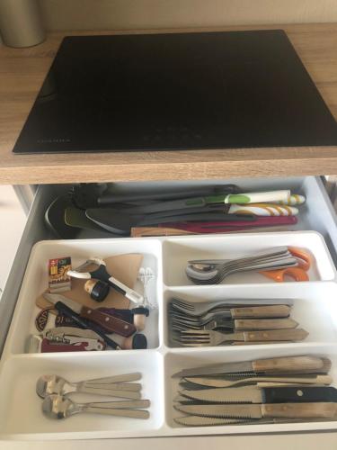 a white drawer full of utensils in a drawer at Appartement 1 chambre De Haan in De Haan
