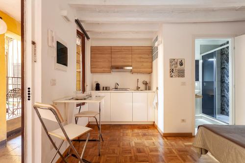eine Küche mit weißen Schränken sowie einem Tisch und Stühlen in der Unterkunft Appartamento Porta Ticinese - Navigli in Mailand