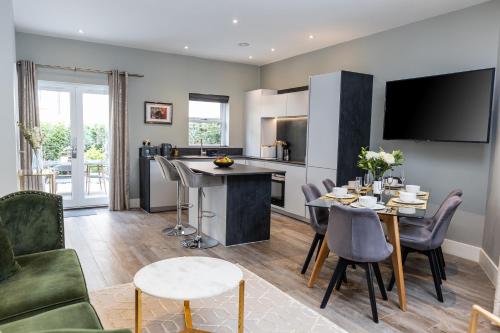 a kitchen and living room with a table and chairs at Elizabeth Mews - By Luxury Apartments in Cheltenham