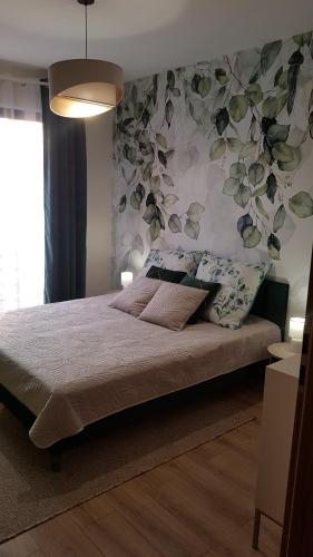 een slaapkamer met een bed met een bloemenmuur bij Domek dwupoziomowy pod Brzozami 4P in Chrzanów