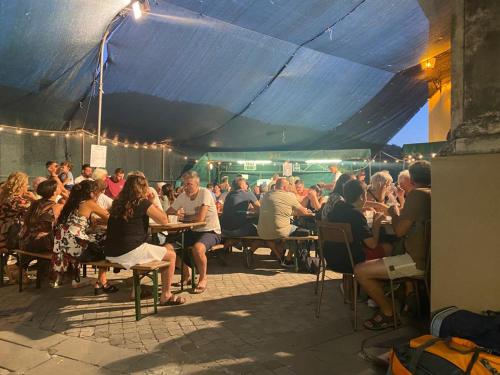 Un grupo de personas sentadas en mesas bajo una carpa. en La casa di Mirella, en Ne