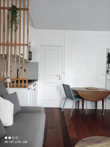 un salon avec un canapé et une table dans l'établissement Logement Stade de France/JO/7 minutes de Paris, à LʼÎle-Saint-Denis