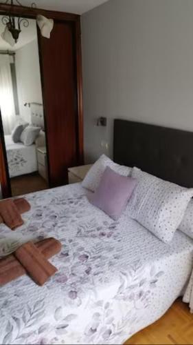una camera con un grande letto con un cuscino viola di Apartamento La Curtidora ad Avilés