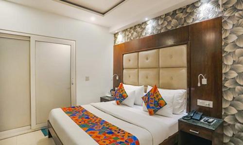 a bedroom with a large bed with a wooden headboard at FabHotel Station I in New Delhi
