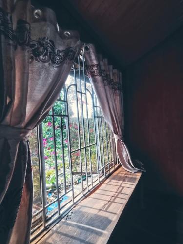 ein Fenster mit einem Vorhang vor einem Fenster in der Unterkunft Lily's Stone Garden Dorm room 