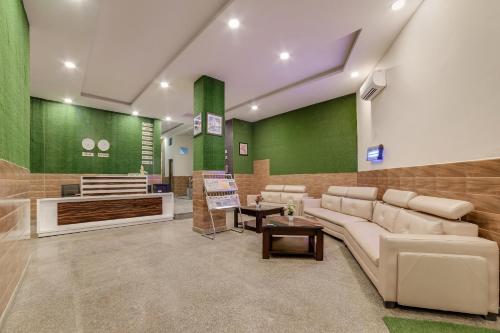 a waiting room with a couch and a table at OYO Flagship THE HOSTEL YARD in Noida