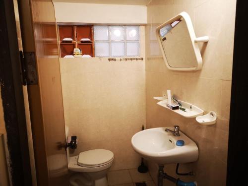 a bathroom with a sink and a toilet and a mirror at TaSahin Hostel & Turkish Restaurant & Bar in Phnom Penh