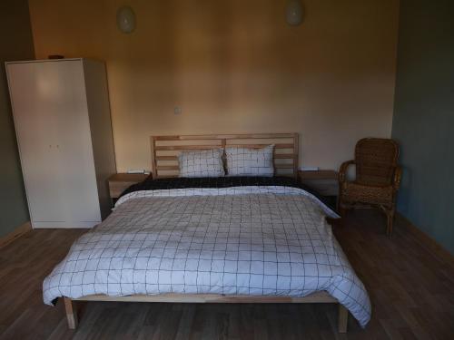 1 dormitorio con 1 cama y 1 silla en Chambre Fischbach, en Chimay