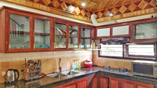 a kitchen with wooden cabinets and a sink at Rose House Sapa in Sa Pa