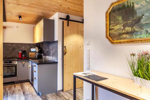 a kitchen with wooden ceilings and a painting on the wall at Chalet Rauschn 1 in Farchant