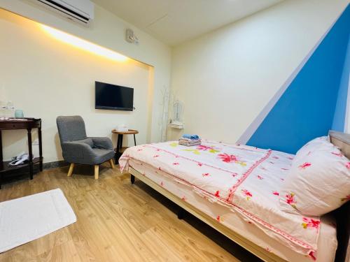 1 dormitorio con 1 cama, 1 silla y TV en Xingang Ping An B&B en Xingang