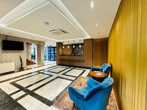 uma sala de estar com duas cadeiras azuis e uma mesa em Nice Royal Suite em Istambul