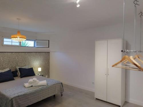 a bedroom with a bed with two towels on it at Apto. El Pozo de las Nieves con piscina in Cobisa