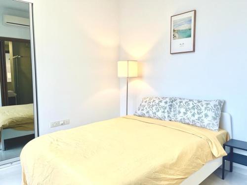 a bedroom with a bed with a yellow bedspread at 2 BR with city view near Subway in central in Singapore