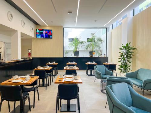 a restaurant with tables and chairs and a large window at Hotel MG Poniente in Las Palmas de Gran Canaria