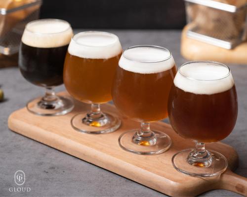 a group of four glasses of beer on a wooden tray at Gloud Hotel in Hanoi