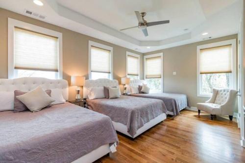 um quarto com 2 camas e uma ventoinha de tecto em East Nashville Oasis: Chic 3BR w/ Rooftop Hot Tub em Nashville