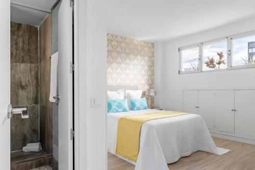 a white bedroom with a bed and a window at Ático Dúplex CuzcoCastellana Smart in Madrid