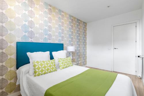 a bedroom with a bed with a blue headboard at Ático Dúplex CuzcoCastellana Smart in Madrid