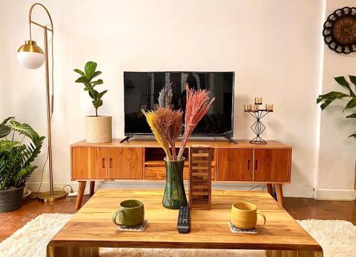 a living room with a tv and a coffee table at Flip Flop In Townhouse in Bangkok