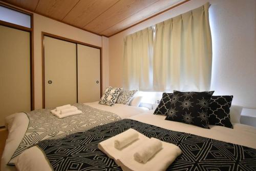 a bedroom with two beds with towels on them at メゾン八千代302 in Tokyo