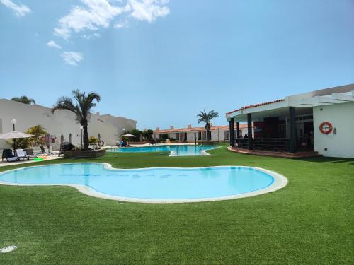 a pool in the middle of a field of grass at Malibu Park Apartments Sol in Adeje