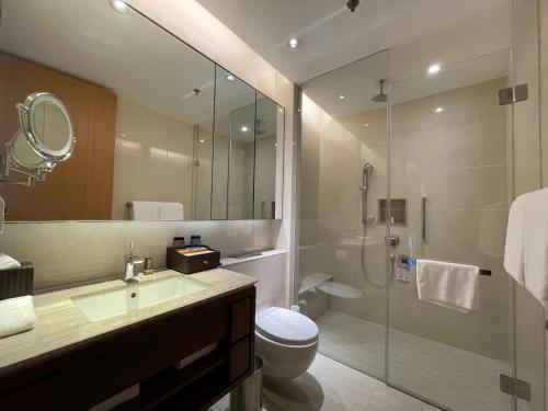 a bathroom with a shower and a sink and a toilet at The OCT Harbour, Shenzhen - Marriott Executive Apartments in Shenzhen