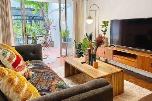 a living room with a large flat screen tv at Flip Flop In Townhouse in Bangkok