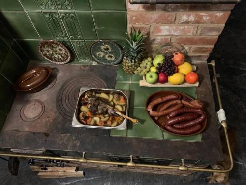 una mesa con platos de comida, carne y fruta en Earthship Mierzeszyn en Mierzeszyn