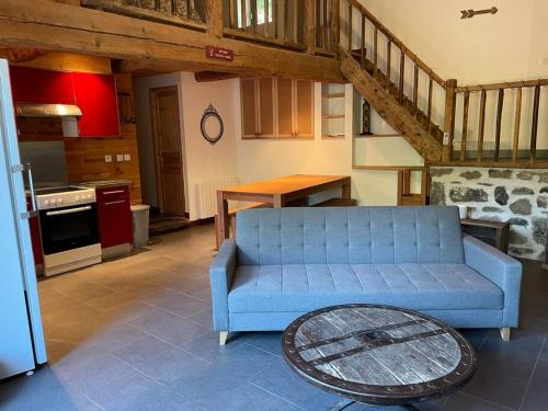 sala de estar con sofá azul en la cocina en La clé des champs de Laumont en Saint-Diéry