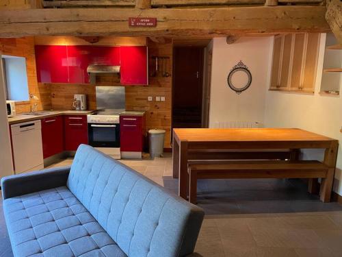 a living room with a blue couch in a kitchen at La clé des champs de Laumont in Saint-Diéry