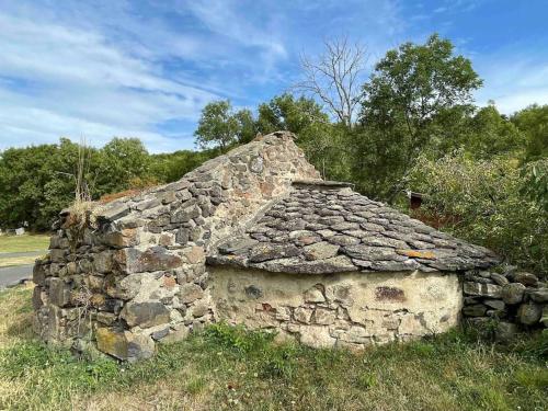 an old stone building sitting in a field at La clé des champs de Laumont in Saint-Diéry