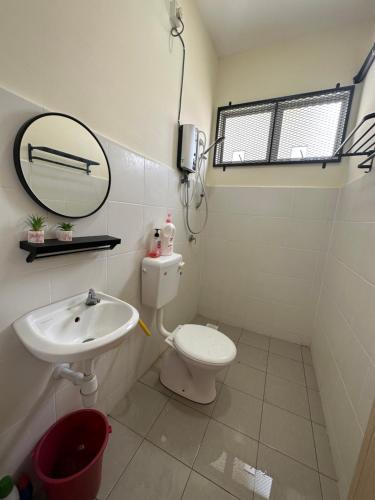 a bathroom with a sink and a toilet and a mirror at CassaNeyna Homestay Kuantan in Kuantan