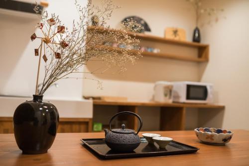 a black vase sitting on top of a wooden table at 喜楽・里桜 in Kyoto
