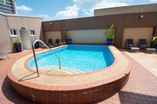 a swimming pool in a brick circle in the middle of a building at Rydges Darwin Central in Darwin