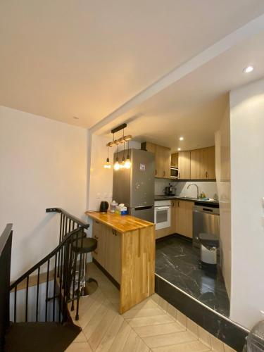 - une cuisine avec un îlot en bois dans l'établissement La Résidence Panthéonique, à Paris