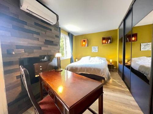 Cette chambre comprend deux lits, un bureau et une table. dans l'établissement Maison piscine privée Camargue, à Vauvert