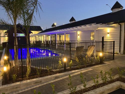 a house with a fence and a swimming pool at night at Newina Rotorua in Rotorua