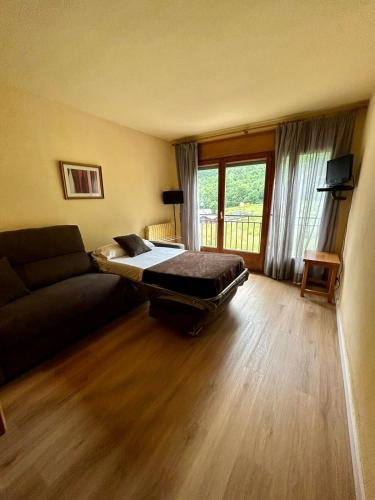 a living room with a bed and a couch at Apartamentos Turisticos Poblado in Arinsal
