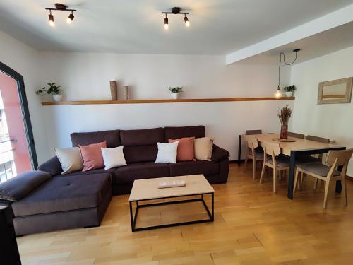 ein Wohnzimmer mit einem Sofa und einem Tisch in der Unterkunft Allotjaments el Pont in Camprodon