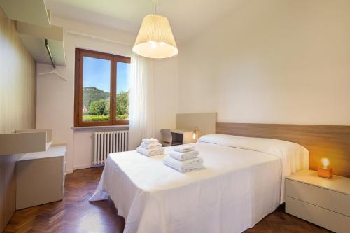Cette chambre blanche dispose de deux lits et d'une fenêtre. dans l'établissement Villa Irene In Bardolino, à Bardolino
