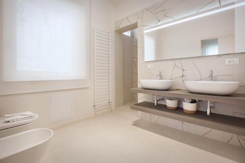 - une salle de bains blanche avec deux lavabos et un miroir dans l'établissement Villa Irene In Bardolino, à Bardolino